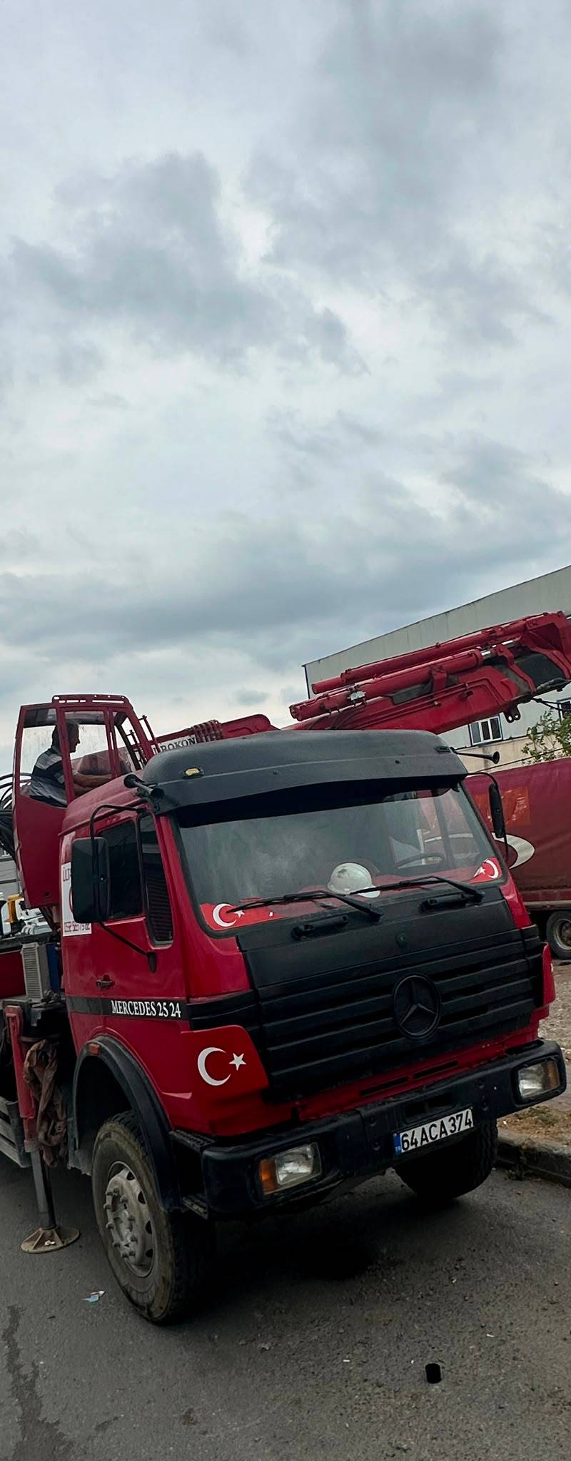 Kırmızı Mercedes vinçli kamyon şantiye sahasında